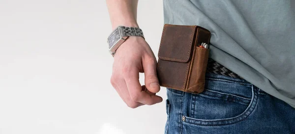 Hombre sostiene en su mano una caja de cigarrillos hecha de cuero artesanal marrón — Foto de Stock