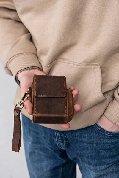 Man holds in his hand a cigarette case made of brown craft leather Stock Picture