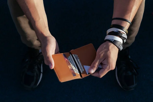Un hombre sostiene una cartera de cuero con billetes de dólar vista superior — Foto de Stock
