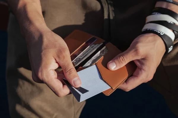 Un hombre sostiene una cartera de cuero con billetes de dólar vista superior — Foto de Stock