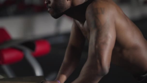Πλευρική άποψη ισχυρή μυϊκή Αφρο-αμερικανική κίνητρα αθλητής κάνει push-ups σε εσωτερικούς χώρους γυμναστήριο. Εξάσκηση σε άντρα με τατουάζ που γυμνάζεται. Αρτιότητα και υγιεινός τρόπος ζωής. — Αρχείο Βίντεο