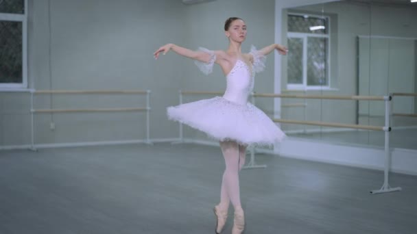 Beyaz etekli zarif balerin dans stüdyosunda parmak uçlarında dans ediyor. Slim Kafkas 'lı genç bir kadın klasik balo dansı adımlarını prova ediyor. Koreografi sanatı ve yeteneği. — Stok video