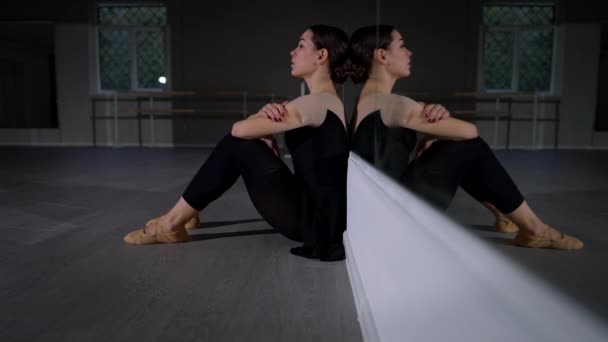 侧视使筋疲力尽的芭蕾舞演员坐在地板上，头靠在镜子前，双膝跪下。疲惫的年轻白人女人在舞蹈工作室里叹息。失败与编舞概念. — 图库视频影像