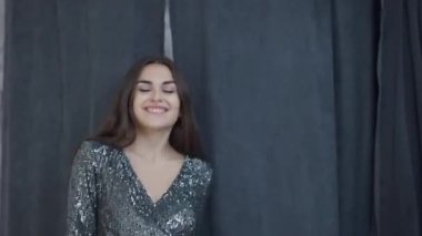 Ön manzara, soyunma odasındaki perdeleri açan ve gülümseyen yeni, ışıl ışıl elbisesiyle kameraya bakan kadını tatmin ediyor. Mağazada zarif kıyafetler içinde poz veren mutlu Kafkas müşterisinin portresi..