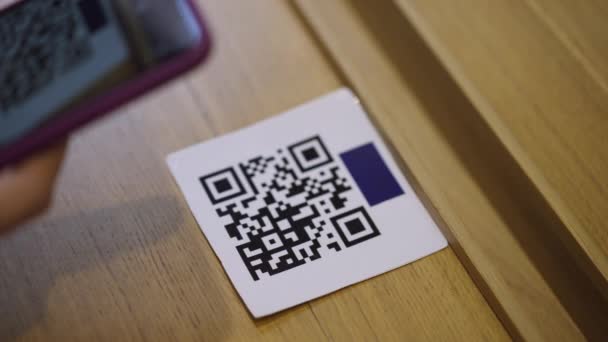 Kode QR close-up di atas meja dengan tangan perempuan memindai menu online dengan aplikasi smartphone di kafe restoran di dalam ruangan. Wanita tak dikenal menggunakan teknologi modern untuk memesan makanan dan minuman. Kenyamanan.. — Stok Video