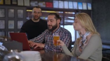 Pozitif gülümseyen adam bilgisayarını kapatıyor arkadaşlarıyla kadeh tokuşturuyor barda bira içip maç seyrediyor. Kafkasyalı kadın ve erkekler hafta sonları evde eğleniyor..
