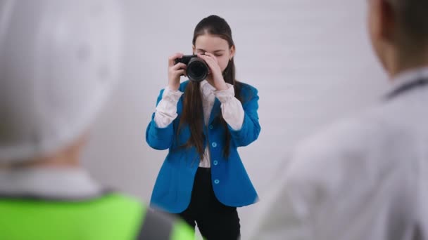 Pensativo concentrado talentoso adolescente menina tirar foto com câmera. Atirar sobre o ombro de amigos posando para o pequeno fotógrafo caucasiano. Escolha da profissão e conceito de criatividade. — Vídeo de Stock