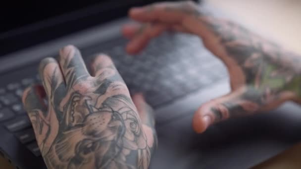 Close-up tatuado mãos masculinas digitando no teclado do laptop. Jovem caucasiano irreconhecível com tatuagens nas palmas das mãos mensagens de e-mail on-line sentado dentro de casa. — Vídeo de Stock