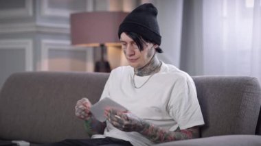 Genç adam zarfı açıyor. Mektupları okuyor, kağıtları atıyor. Memnuniyetsiz Kafkas dövmeli adamın portresi evdeki oturma odasında kanepede oturarak kötü haberler alıyor. Sorunlar ve sorunlar.