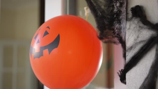 Close-up jack olantern ballon en zwarte spinnenweb opknoping op huis versierd met Halloween. Traditionele decoraties op Allerheiligen buiten. Vakantie concept. — Stockvideo