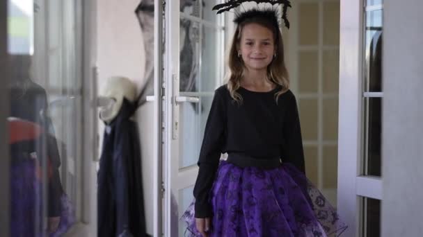 Portrait of cute charming girl spinning posing in Halloween costume with bat headband. Happy Caucasian kid smiling looking at camera standing indoors at home. Traditions and holidays concept. — Stock Video