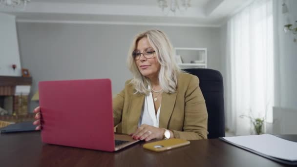 Psikolog ahli positif duduk di meja berselancar Internet pada laptop. Potret wanita Kaukasia elegan yang bekerja secara online membaca berita medis. Kecerdasan dan gaya hidup. — Stok Video