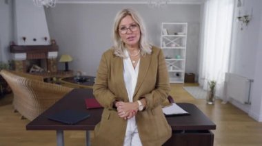 Ön görüş uzmanı kadın psikolog video kayıt bloguna bakarak konuşuyor. Gözlüklü güzel beyaz kadın portresi çevrimiçi zihinsel bozuklukları açıklayan blog yazıyor.