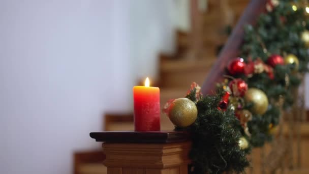 Χριστουγεννιάτικο κερί και στολίδια στις σκάλες με θολά καυκάσια παιδιά να τρέχουν κάτω και να φεύγουν. Ευτυχισμένο αγόρι και κορίτσι παραμονή Πρωτοχρονιάς στο σπίτι. Χριστούγεννα έννοια εορτασμού. — Αρχείο Βίντεο