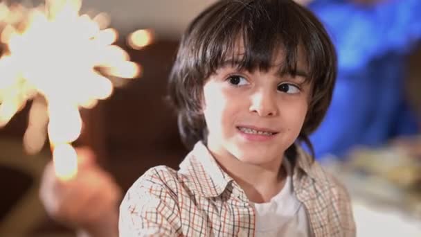Headshot menino feliz do Oriente Médio com brilho de Natal olhando para a câmera sorrindo. Close-up retrato criança relaxada celebrando Ano Novo em casa dentro de casa posando. Conceito de milagre e feriado. — Vídeo de Stock