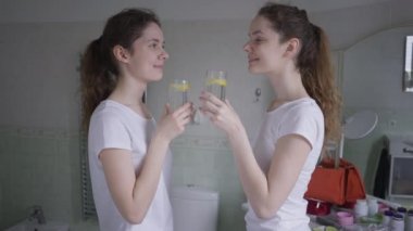 Mutlu, genç ve güzel kadınlar bardaklarını tokuşturup limon suyu içerek ferahlatıcı bir gülümseme tadacaklar. Kafkasyalı ikiz kız kardeşler içeride sağlık ve güzellikle ilgileniyorlar.