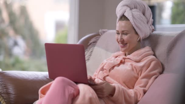 Porträtt av avslappnad glad vit ung kvinna viftar på bärbar dator videochatt talar i slow motion leende. Glad bekymmerslös tusenårig dam meddelanden online på helgen morgon hemma. — Stockvideo