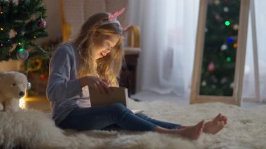 Tasasız, güzel, Kafkasyalı küçük kız Noel arifesinde evde içinde ışık olan bir kitap açıyor. Yeni yılda evde masal okuyan heyecanlı bir çocuğun geniş açılı portresi..