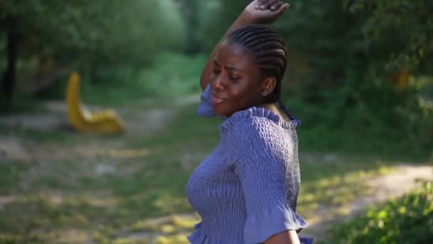 Sidovy glad säker plus storlek kvinna dansar i slow motion i sommarparken. Glad vacker afroamerikansk dam har roligt njuter hobby i solsken. Kroppslig positiv livsstil. — Stockvideo