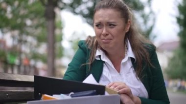 Ağlama portresi yanmış, iri yarı bir kadın elinde kutuyla bankta oturuyor. Rüzgarlı bir günde şehir caddesinde sinirli, beyaz, kilolu bir kadın kovuldu. Stres ve sorun kavramı.