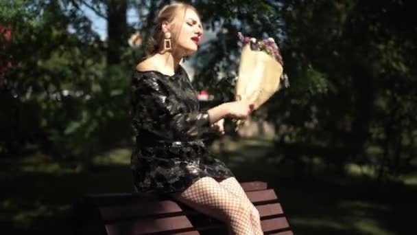 Drunken young woman with broken heart twirling flowers throwing bouquet away laughing out loud. Portrait of beautiful drunk Caucasian party-goer in sunny park outdoors. — Stock Video