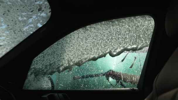 晴天室外,洗车洗发水缓缓地洗在车侧窗上.洗车服务的汽车清洗. — 图库视频影像
