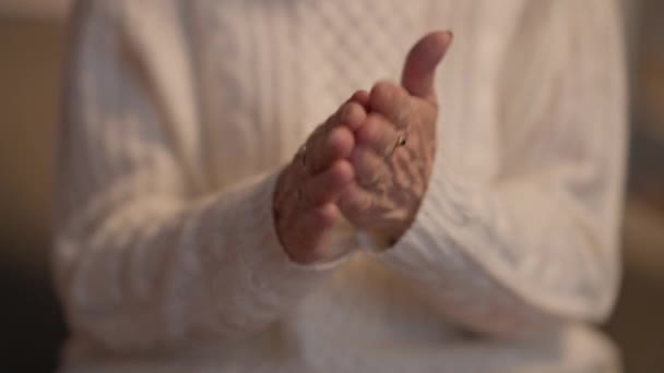 Close-up Senior faltige weibliche Hände reiben Feuchtigkeitscreme in Innenräumen. Unerkennbarer kaukasischer Rentner, der sich zu Hause um Haut und Schönheit kümmert. Alterung und Weiblichkeit. — Stockvideo