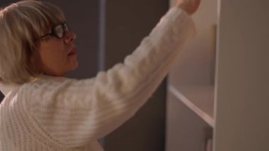 Kitaplıkta kitap seçen Kafkas kıdemli kadın ayrılıyor. Güzel, zeki, emekli bir kadın oturma odasında hobisinin keyfini çıkarıyor. Yaşam tarzı ve mutluluk kavramı.