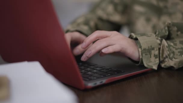 Női kezek álcázás gépelés laptop billentyűzeten lassított felvételen. Felismerhetetlen kaukázusi fiatal nő katonai egyenruhában szörfözés Internetes üzenetküldés az asztalnál ülve. — Stock videók