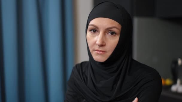 Deprimovaná žena ze Středního východu si myslí, že sedí sama doma. Portrét smutné zoufalé osamělé dámy v tradičním černém oděvu odkládající. Kamera se pohybuje. — Stock video