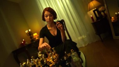 Bakış açısıyla düşünceli muhteşem bayan satranç oyuncusu satranç tahtasına taş koyup içeride puro içiyor. Odaklanmış güzel beyaz saçlı kadın oyun stratejisi uyguluyor..