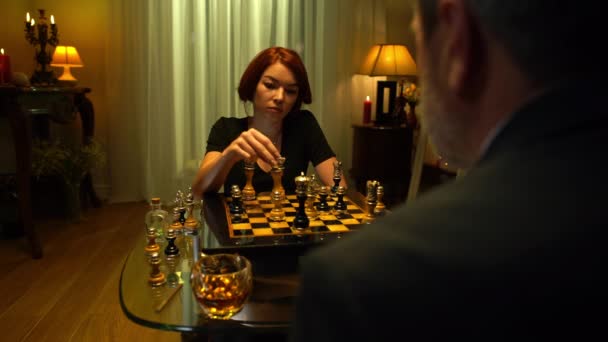 相手と握手する王をノックダウン男として自信のある女性がチェスのフィギュアを移動します。満足した白人の赤毛の勝者の肖像室内で勝利ゲーム握手笑って. — ストック動画