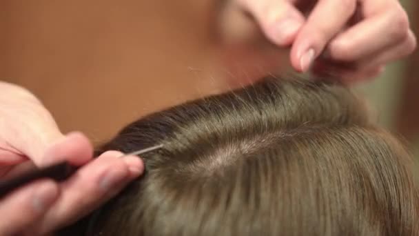 Крупным планом расчесывание волос и кёрлинг плоским утюгом. Мужские руки с помощью выпрямителя для волос с соплом для завивки в салоне красоты в помещении. Концепция прически. — стоковое видео