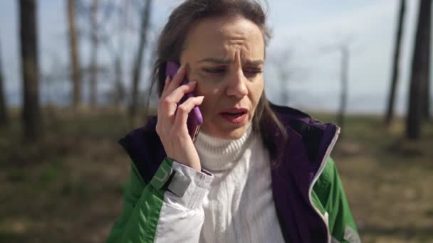 Αγχωμένη γυναίκα που μιλάει στο τηλέφωνο μόνη της στο δάσος. Πορτρέτο ανήσυχος Καυκάσιος γυναίκα τουρίστας χάνει κινητό σήμα ταξιδεύοντας σε εξωτερικούς χώρους το Σαββατοκύριακο. Τουριστικά προβλήματα. — Αρχείο Βίντεο