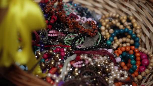 Κοντινό πλάνο διάφορα πολύχρωμα bijouterie βρίσκεται σε ψάθινο καλάθι σε εσωτερικούς χώρους. Παραδοσιακά εξαρτήματα της Ουκρανίας για διακόσμηση της εθνικής φορεσιάς. — Αρχείο Βίντεο