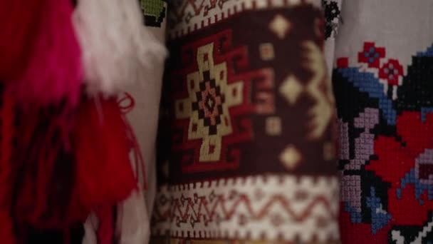 Gros plan broderie ukrainienne traditionnelle à la main sur manche de costume national. Ornement folklorique sur vêtements suspendus à l'intérieur. Mouvement lent. — Video