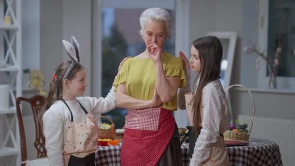 Nipotine affascinanti calmare triste nonna caucasica in piedi in casa. Ritratto di ragazze premurose che abbracciano donna sconvolta. Concetto di sostegno e sostegno alla famiglia. — Video Stock