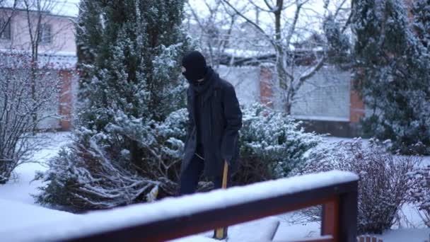 Live camera follows robber in ski mask walking to entrance door with baseball bat looking around. Suspicious concentrated Caucasian man in balaclava breaking in house trespassing private property. — Stock Video