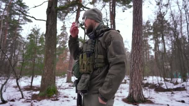군복을 입고 선글라스를 쓰고 웃고 있는 백인 청년. 미디엄은 겨울 숲 속에서 촬영 한 자신있는 우크라이나 전사의 사진. — 비디오