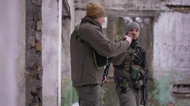 İki ciddi Ukraynalı asker yumruklaşıp silahlarıyla kaçıyor. Silahları olan cesur, Kafkasyalı genç adamlar harabe şehri terk ediyorlar. Savaş çatışması ve savunma kavramı.