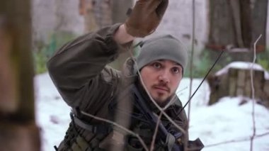 Ciddi asker hareketlerinin portresi harabe şehirde saklanan gruba gidiyor. Silahlı yakışıklı genç Ukraynalı asker birliğiyle ülkeyi terk ediyor. Savunma ve işgal kavramı.