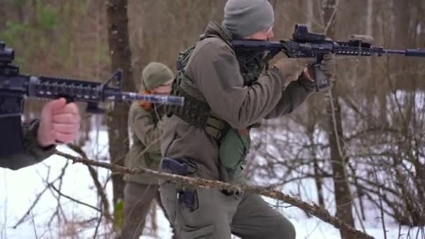 Oldalnézet fegyveres katonák, akik lassított felvételen sétálnak a téli erdőben a szabadban. Magabiztos fiatal férfiak és nők harcolnak megszállókkal Ukrajnában. Katonai eszkaláció és háborús koncepció. — Stock videók