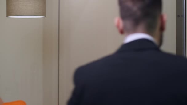 Vermoeide jongeman in pak passeert glazen kantoor binnen. Portret van een vermoeide blanke man die zucht terwijl hij binnenkomt. Bedrijven en levensstijl. — Stockvideo