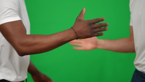 Close-up tinggi-lima jabat tangan Afrika Amerika dan Kaukasia tim sepak bola di layar hijau. Seorang olahragawan muda yang tidak dikenal mengucapkan selamat tinggal meninggalkan latar belakang kromakey. — Stok Video