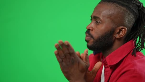 Anxious worried football fan supporting team reacting emotionally on green screen. Side view close-up of African American man watching soccer match at chromakey background. — стоковое видео