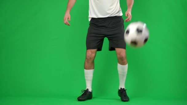 Desportista caucasiano irreconhecível pegando bola de passagem em câmera lenta na tela verde. Jovem futebolista profissional jogando jogo em cromakey fundo. — Vídeo de Stock