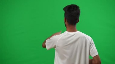 Orta Doğu futbol koçu yeşil ekran şablonunu işaret ediyor. Kromakey arka planında konsantre ciddi adam kontrol oyunu. Spor ve uzmanlık konsepti.