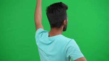 Arka planda, elinde Alman bayrağı sallayan Orta Doğulu bir adam şampiyonluk maçında futbol takımını destekliyordu. Motive olmuş genç hayran sevinçle seviniyor kromakey yeşil ekran arka planda tezahürat.