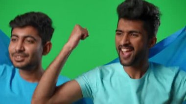 Heyecanlı Orta Doğulu erkekler sevinçle atlayıp yeşil ekranda Ukrayna futbol takımı için tezahürat yapıyorlar. Kromakey arka planında bayrağıyla futbol maçı izlerken gülümseyen pozitif yakışıklı hayranlar..