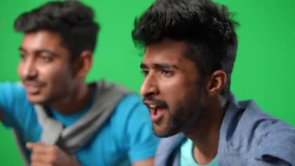 Boční pohled portrét emocionálně úzkostlivý muž z Blízkého východu jásající s přítelem podporující fotbalový tým na zelené obrazovce. Znepokojení mladí fanoušci křičí gestikulující na pozadí chromakey. — Stock video